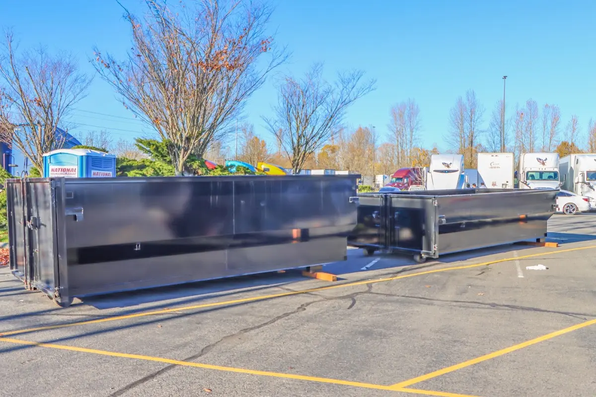 Professional dumpster rental service with roll-off container on residential driveway in Kingsford